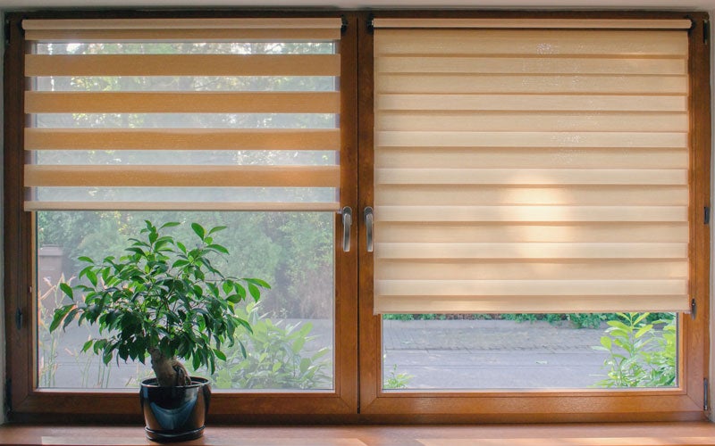Bright sunroom with white sectional sofa and glass table