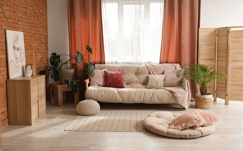 ozy living room with sofa, plants, and warm decor tones