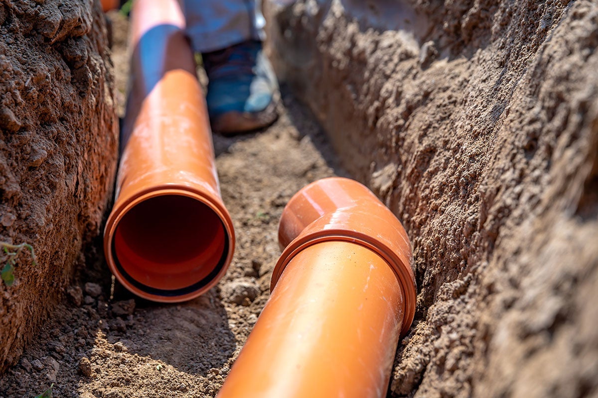 Orange PVC sewage pipes laid in a trench for underground construction